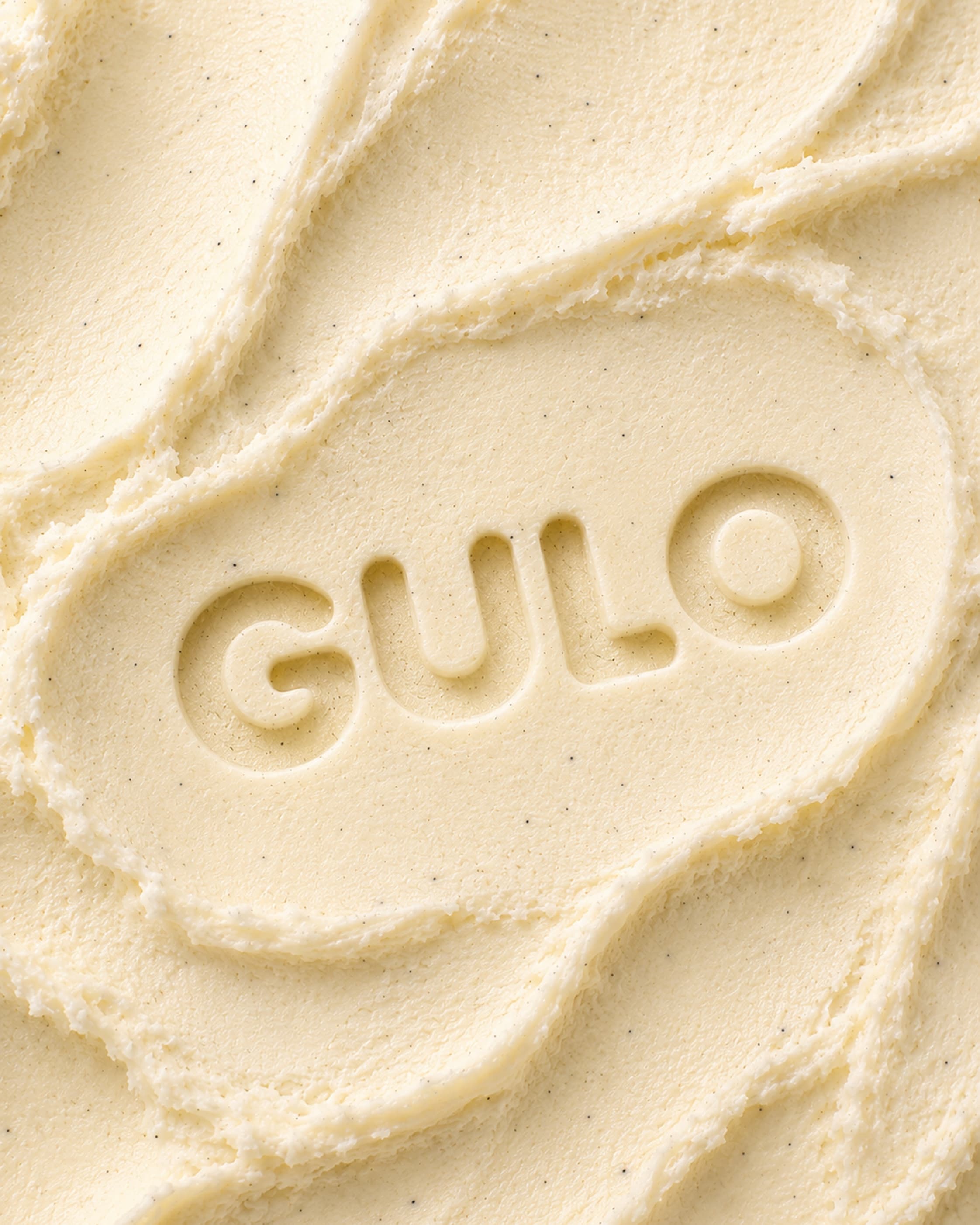Textura cremosa de sorvete de baunilha com marca Gulo em baixo relevo
